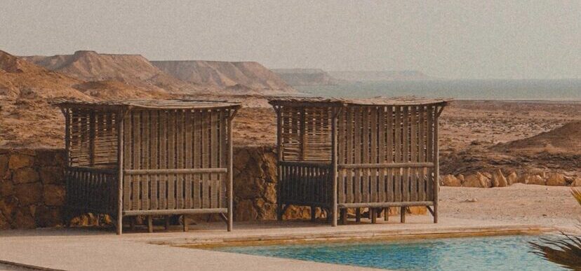 The Dakhla landscape creates a hazy backdrop against a shimmering pool.